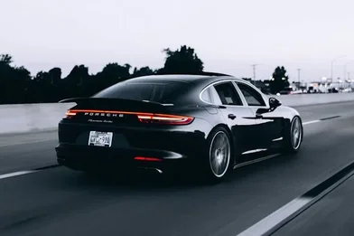 Xe sedan đen nhìn từ phía sau đang chạy trên đường cao tốc