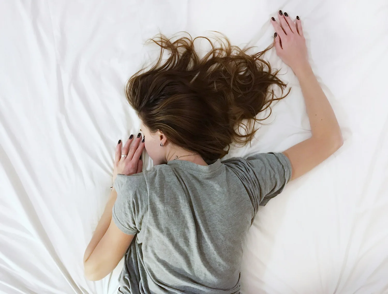 02:00 giấc ngủ sâu — người ngủ say úp mặt trên nệm trắng, tóc xõa